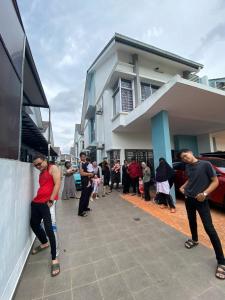 un grupo de personas parados fuera de un edificio en Hud hud Homestay Gelang Patah en Nusajaya