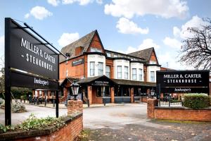 a large brick building with signs in front of it at Miller & Carter Heaton Chapel by Innkeeper's Collection in Manchester