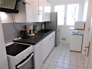 a kitchen with white cabinets and a stove top oven at Appartement Morvan in Sarzeau +10 photos