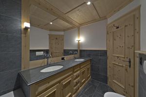 a bathroom with two sinks and a large mirror at Chesa Sur Puoz 15 - Samedan in Samedan