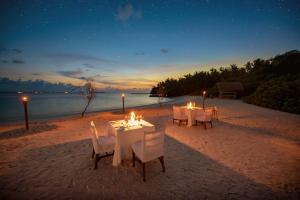 una mesa puesta en la playa por la noche en Makunudu Island en Makunudhoo