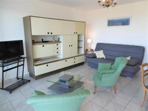un soggiorno con divano blu e TV di Appartement Morvan a Sarzeau