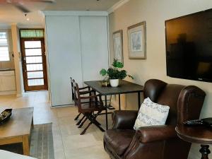 a living room with a couch and a table at Beach Road Studio in Cape Town