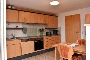 a kitchen with wooden cabinets and a wooden table with a tableablish at Elisa Ferienwohnung in Wadern