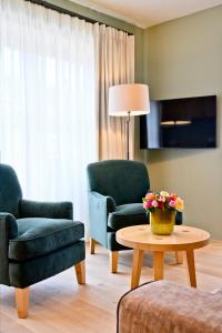 若特阿赫－埃根的住宿－Bachmair Weissach See-Apartments，客厅配有两把椅子和一张桌子
