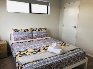 a bedroom with a bed with towels on it at Modern & Luxurious Home 2 in Auckland