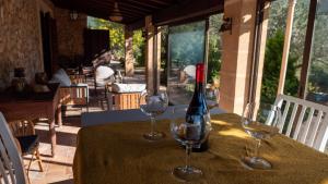 uma mesa com dois copos de vinho e uma garrafa em Es Talaiot em Puigpunyent