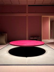 a pink table in the middle of a room at 萌蘖　露天風呂とサウナがある現代の湯治場 in Kagoshima