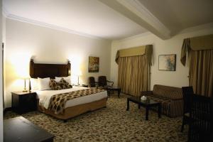 um quarto de hotel com uma cama e um sofá em Hotel Hillview Islamabad em Islamabad