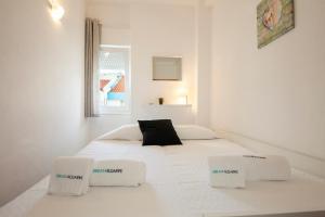 um quarto branco com uma cama branca e 2 cadeiras em Rising Sun Apartments em Lagos