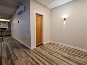um quarto vazio com uma porta e piso de madeira em M Residence New Cairo - Families only no Cairo
