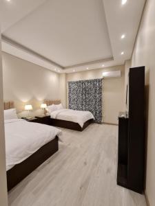 a hotel room with two beds and a window at M Residence New Cairo - Families only in Cairo +35 photos