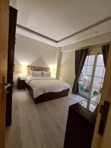 a bedroom with a large bed and a large window at M Residence New Cairo - Families only in Cairo