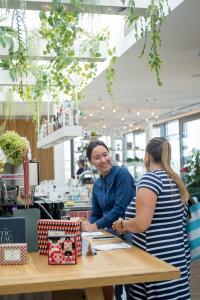 Deux femmes debout à une table dans un magasin dans l'établissement Zoku Vienna, à Vienne