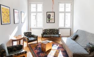 ein Wohnzimmer mit einem Sofa und Stühlen in der Unterkunft Stylishly redecorated apartment in great location in Budapest