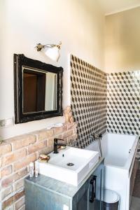 ein Badezimmer mit einem weißen Waschbecken und einer Ziegelwand in der Unterkunft Stylishly redecorated apartment in great location in Budapest