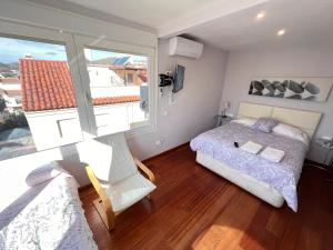 ein Schlafzimmer mit einem Bett und einem großen Fenster in der Unterkunft El N5 Casa en Rincon de la Victoria Golf & Piscina in Rincón de la Victoria