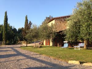 deux chaises assises sur l'herbe devant une maison dans l'établissement Podere Poggio Benedetto, à Saturnia
