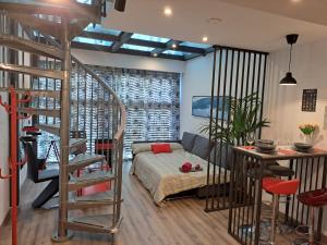 een woonkamer met een bed en een wenteltrap bij Moraleja Suite I in Alcobendas