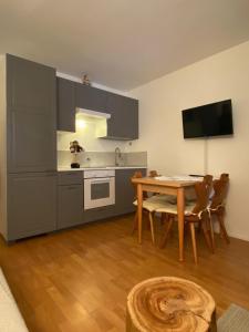 a kitchen with a table and a dining room at Appartamento a 2,5 km da Alleghe in Alleghe