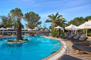 a pool with lounge chairs and umbrellas at a resort at Mediterranean Princess- Adults Only in Paralia Katerinis