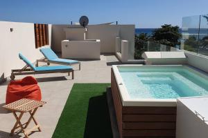 un cortile con piscina e un patio con sedie di Penthouse vue sur mer 200m2 a Pereybere