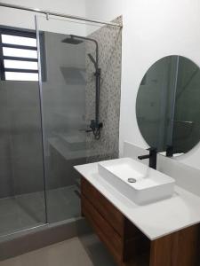 a bathroom with a sink and a glass shower at Penthouse vue sur mer 200m2 in Pereybere