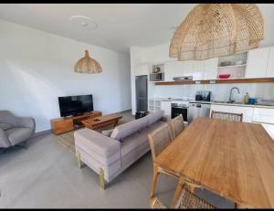 uma sala de estar com um sofá e uma mesa de madeira em Penthouse vue sur mer 200m2 em Pereybere