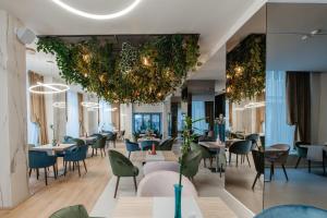 a restaurant with tables and chairs and a large chandelier at Hotel Clipa in Drobeta-Turnu Severin