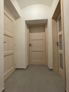 an empty hallway with two doors and a tile floor at Rocky Apartment in Rokytnice nad Jizerou
