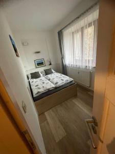 um pequeno quarto com uma cama e uma janela em Rocky Apartment em Rokytnice nad Jizerou