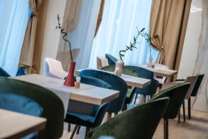 a dining room with tables and chairs and windows at Hotel Clipa in Drobeta-Turnu Severin