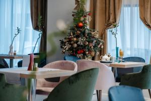 een kerstboom in een restaurant met tafels en stoelen bij Hotel Clipa in Drobeta-Turnu Severin