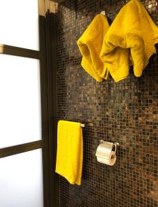 uma casa de banho com toalhas amarelas penduradas numa parede em Un nid à Saint Tropez em Saint-Tropez