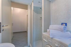 a bathroom with a shower and a toilet and towels at San Donato Fiera Apartment x5! in Bologna +17 photos