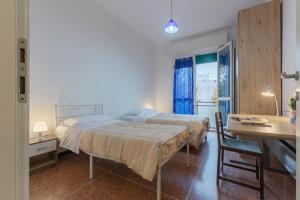 1 Schlafzimmer mit 2 Betten, einem Tisch und einem Schreibtisch in der Unterkunft San Donato Fiera Apartment x5! in Bologna