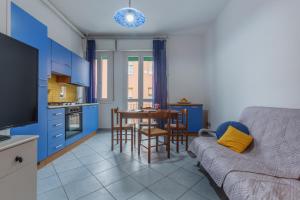 uma sala de estar com um sofá e uma cozinha com armários azuis em San Donato Fiera Apartment x5! em Bolonha