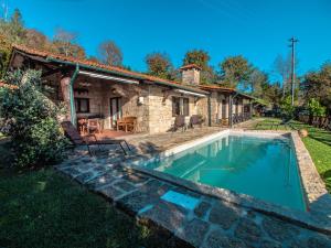 a stone house with a swimming pool in front of a house at Casa da Terra Nova - Gerês in Rio Caldo