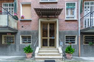 ein Backsteingebäude mit einer Treppe, die zu einer Tür führt in der Unterkunft San Donato Fiera Apartment x5! in Bologna