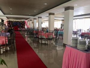 a banquet hall with pink tables and chairs and a red carpet at OYO 921 Sorrento Hotel And Resort 