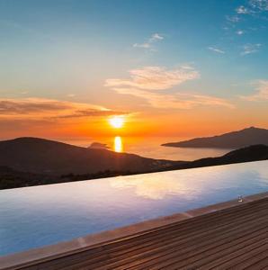 una puesta de sol sobre una piscina con el sol en el cielo en Villa Ilda - Deluxe Holiday Villa - KALKAN-ANTALYA, en Kalkan