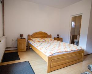 a bedroom with a wooden bed and two night stands at Casa Tibi in Praid