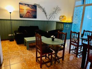 een woonkamer met een tafel en een bank bij El jardin de Iris in Santa Cruz de Tenerife