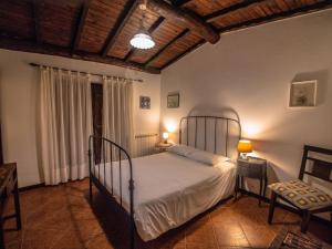 a bedroom with a bed and two tables and a chair at Casa da Terra Nova - Gerês in Rio Caldo