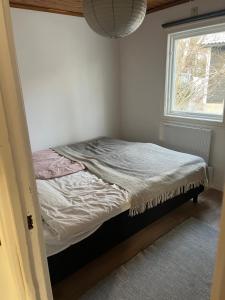 een klein bed in een kamer met een raam bij Cosy house in the archipelago in Värmdö