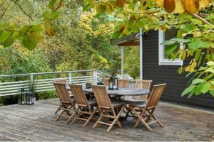 a wooden table and chairs on a deck at Cosy house in the archipelago in Värmdö