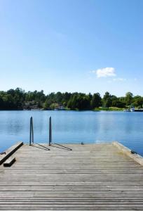 a dock on a lake with trees in the background at Cosy house in the archipelago in Värmdö