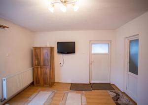 an empty living room with a tv and a door at Casa Tibi in Praid
