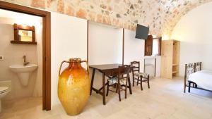 a large vase sitting in a room with a table at Borgo Miceli in Locorotondo +70 photos