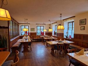 a restaurant with wooden tables and chairs and windows at Landgasthof Krone in Senden